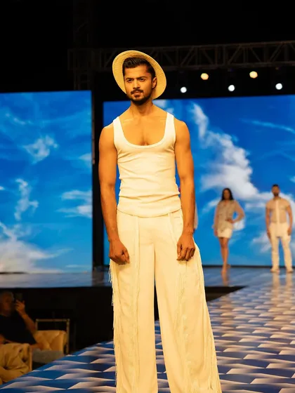 A resort wear look for designer Chaitanya Rao at Mysore Fashion Week. This all-white ensemble with a straw hat captures a relaxed yet chic vacation vibe.