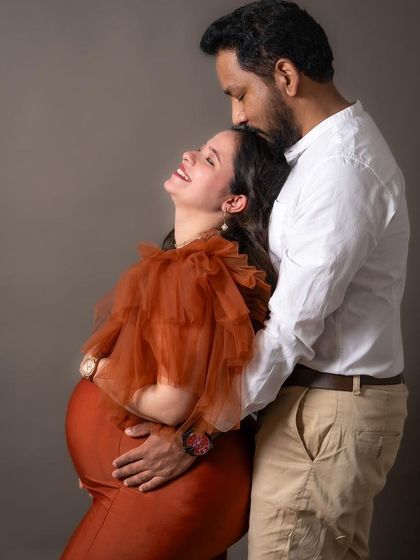 A joyful and candid moment between a couple. The client's happy expression says it all, comfortable and beautiful in our Bronze gown.