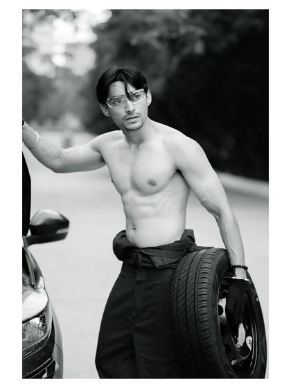 A conceptual men's fitness portrait. The black and white treatment accentuates the subject's physique and the gritty, determined mood of the shot.
