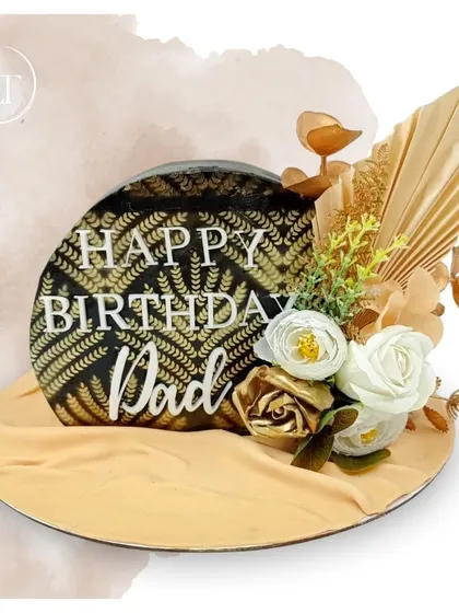 An elegant and masculine birthday cake for Dad, featuring a black and gold patterned design and white and gold roses.