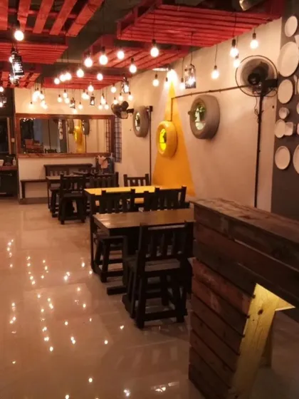 We love creating commercial vibes that feel authentic. For this eatery, we used a palette of industrial materials like exposed bulbs, dark wood, and a custom pallet ceiling to build a warm, down-to-earth atmosphere that invites people to stay awhile.