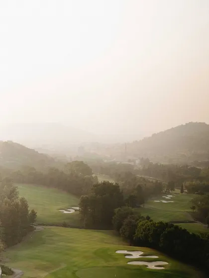 The beautiful, hazy landscape of the Oxford Golf course at sundown. This establishing shot sets the scene for a romantic and picturesque pre-wedding session.