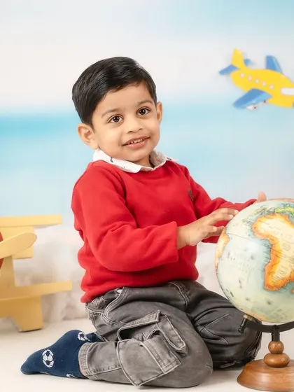 This little explorer is fascinated by the globe, dreaming of all the places he'll go. Interactive props are key to a successful toddler shoot.