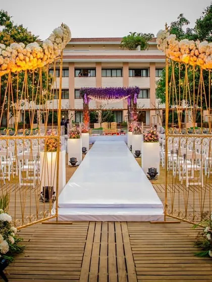 I designed this elegant outdoor entrance with golden arches adorned with white roses, leading to a pristine white aisle. It framed the venue beautifully and created a classic, romantic start to the ceremony.