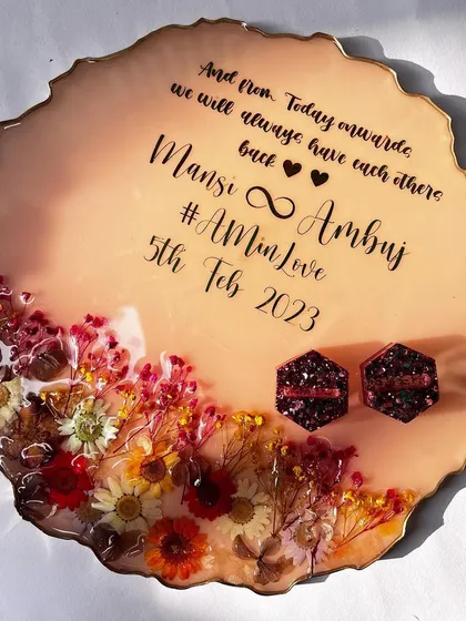 This 10-inch platter features a warm, peachy base with a crescent of colorful preserved flowers. The design is personalized with a heartfelt quote and the couple's names.