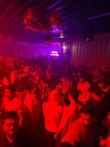 Another view of the packed house, with red and purple lights creating an intense party atmosphere.