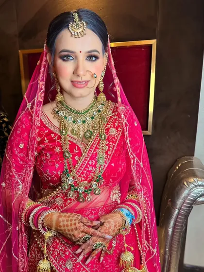 A full view of the bride's look, showing how the soft makeup complements her bright pink lehenga.