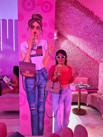Twinning with the decor at a pink-themed cafe in Delhi. I styled a red crop top with light-wash baggy jeans and white sunglasses for a fun, casual look that perfectly matched the Barbie-core vibe.