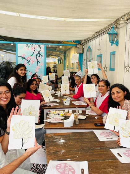 A room full of happy artists holding up their finished floral texture pieces. The collective sense of accomplishment is amazing.