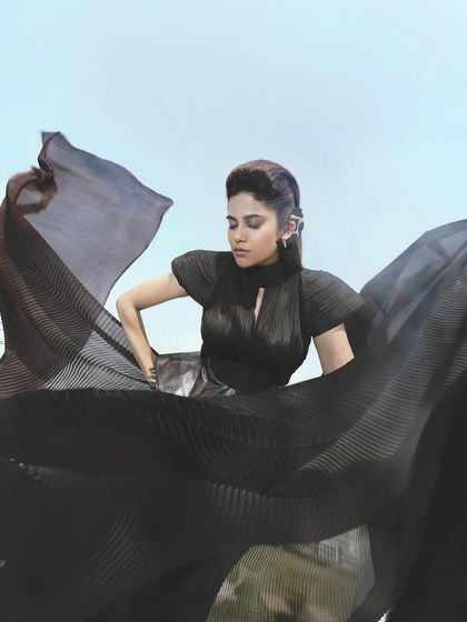 A dynamic shot where the movement of the fabric is the focus. The makeup on Aaditi Pohankar is kept strong and defined to hold its own against the dramatic, flowing black outfit.