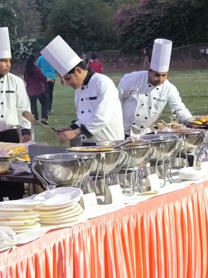 A close-up of our chefs working at a live buffet station during a daytime event. Their professional uniforms and focused preparation demonstrate our commitment to quality and hygiene.