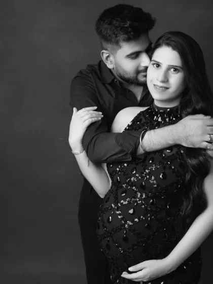 A beautiful monochrome portrait of the couple. The father-to-be wraps his arms around his partner, creating a feeling of love and protection.