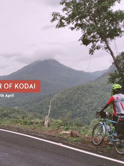 A rider stops to admire the majestic peaks on our 'Tour of Kodai'. The tour is scheduled to give you the best weather and views, making it a perfect escape for discerning travelers.