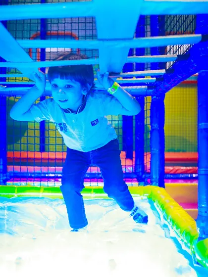 A child navigating an obstacle in our play maze, illuminated by colorful lights for an extra sensory experience.