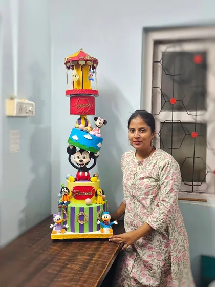 Here I am with the completed 13kg Mickey Mouse Clubhouse cake, after a long day of travel and on-site assembly.