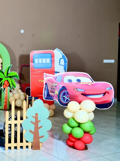 A life-sized cutout of Lightning McQueen next to a fuel pump prop, bringing the world of 'Cars' to life for the kids.