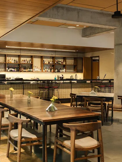 Welcome to my restaurant, Coracle, located at the Bangalore International Centre. I wanted to create a space that feels modern but not stiff, perfect for a cozy family dinner or a quiet meal. We also have a full bar to help you unwind.