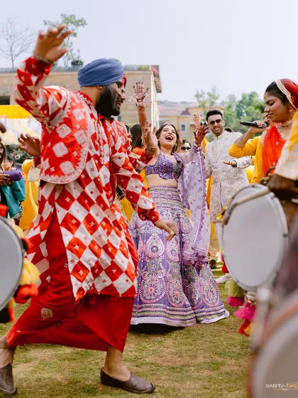 The bride dances with abandon as a dhol player brings infectious energy to the Haldi ceremony. A moment of pure, joyful celebration.