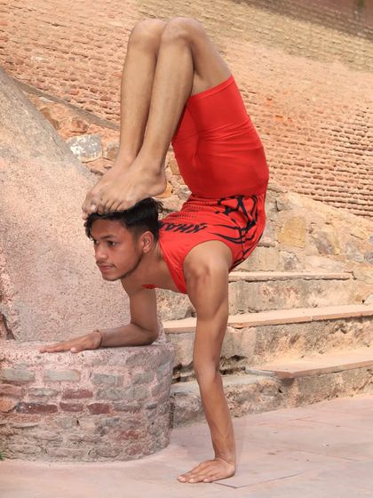 Using the environment to train. This one-hand handstand variation uses a stone block for stability, showing how we can practice anywhere.