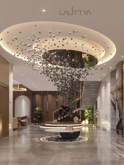 A visualization of a breathtaking entrance foyer designed to make a lasting first impression. The focal point is a mesmerizing chandelier made of cascading metallic elements, set within a circular ceiling detail with warm, recessed lighting.