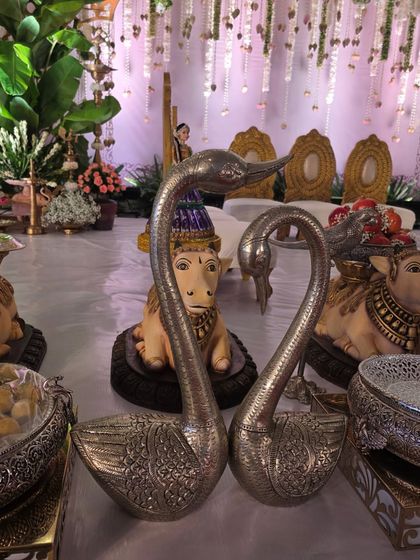 A pair of silver swan props, often used to add elegance to the offering table display.