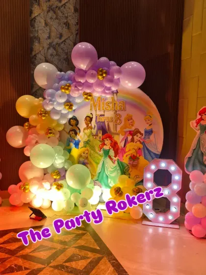 Another view of the main stage for the princess party, showing the character cutouts of Rapunzel and Ariel flanking the central backdrop.