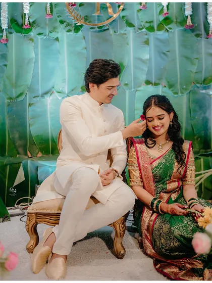 A tender moment during a traditional Saakharpuda ceremony, where the groom-to-be adorns his bride with a flower, a simple yet deeply romantic gesture.