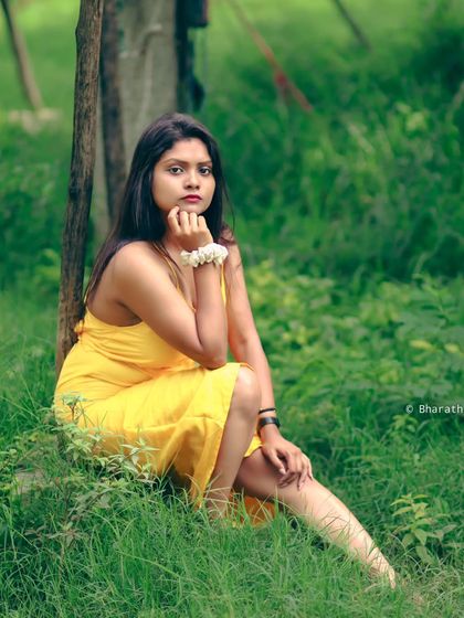 A calm and serene portrait, seated in the grass. The natural surroundings create a peaceful and beautiful atmosphere.