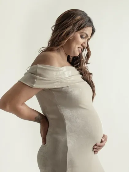 A tender moment captured in a solo portrait. The way she looks down at her bump, hand placed protectively, speaks volumes about the love she already feels.