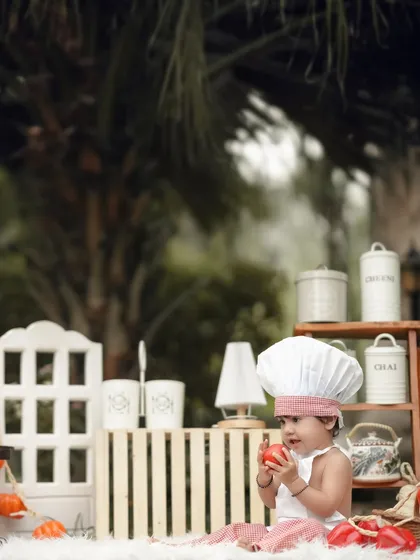 An apple a day for this little chef. This outdoor kitchen setup is full of charming details, creating a perfect backdrop for a playful photoshoot.