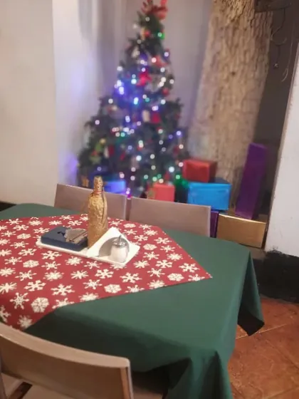 A table with a view of the Christmas tree and presents, capturing the magic of the season.