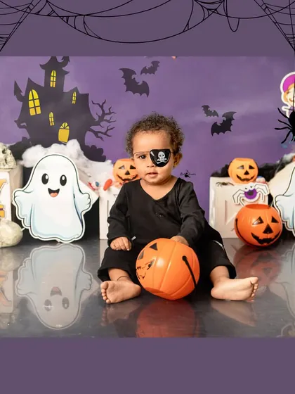 A little pirate for Halloween. We provide a variety of cute costumes and props like eye patches for our themed sessions.