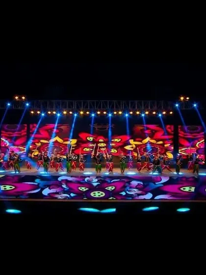 Our stage lighting capabilities can create spectacular effects. Here, beams of light cut through the darkness, highlighting the performers and adding a professional polish to this school's annual day event.