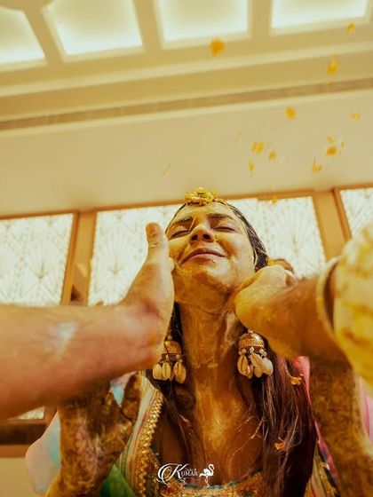 A unique point-of-view shot of the bride as haldi is applied to her face.