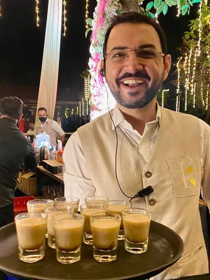 Service with a smile. Our founder is hands-on at events, here serving a tray of our signature chai shots and ensuring every guest feels welcomed and looked after.
