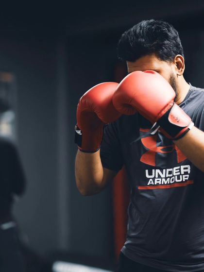 A boxer works on his defense and punching technique against a heavy bag.