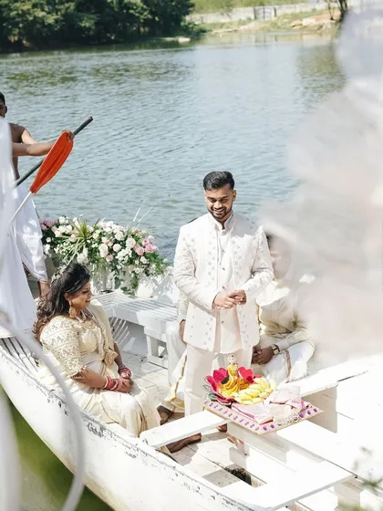 A unique groom's entry on a beautifully decorated boat for this lakeside engagement ceremony. Personal touches like this make a wedding truly unforgettable.