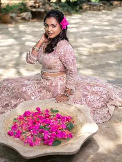 A close-up of the model's face, with a flower in her hair. The makeup is soft and pretty, enhancing her natural beauty.