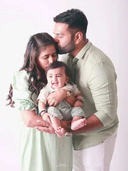 Pure bliss. The smiles on their faces say it all as they cuddle their little one. This is a classic family portrait that radiates warmth and happiness.