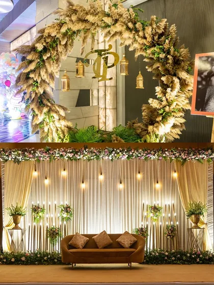 A beautiful Roka ceremony stage, featuring a large wreath of pampas grass and a custom monogram.
