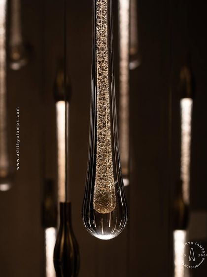 A stunning cluster of crystal teardrop pendants. Each pendant contains bubble-like inclusions that catch the light, creating a sparkling, rain-like effect. This is an elegant choice for double-height foyers or modern staircases.