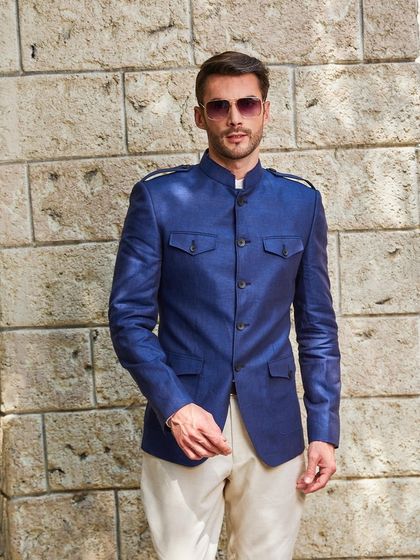 This is my take on a hunting jacket, reimagined as a bandhgala. Made from Irish linen in a striking cobalt blue, it features four pockets and shoulder epaulets for a stylish, utilitarian look.