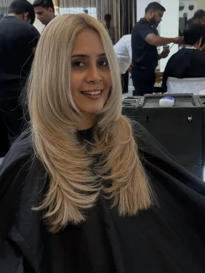 Another smiling shot of this beautiful blonde look. The layered cut adds movement, while the color is bright and eye-catching.