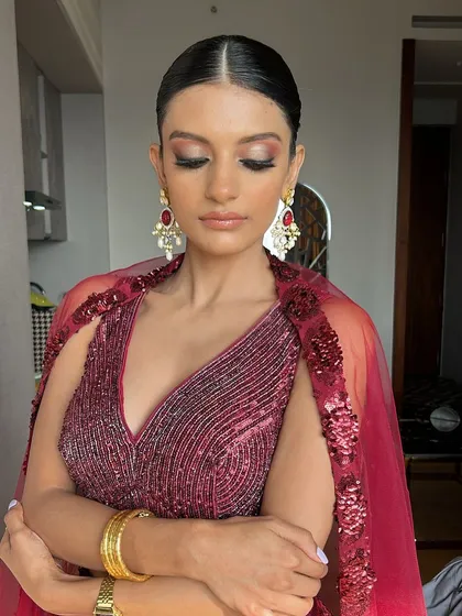 A close-up on the eye makeup. The warm, reddish tones on the eyes complement the outfit perfectly, creating a cohesive and striking look.