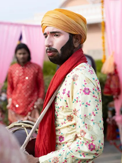 A dhol player in traditional attire, ready to bring the high-energy beats of Punjab to the party. The combination of DJ and dhol is always a crowd favorite.
