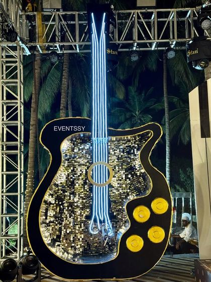 Another view of the sequined guitar prop, showing its impressive scale and sparkling detail under the stage lights.