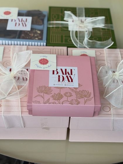 A collection of our pretty pink and green Rakhi hamper boxes, tied with delicate ribbons and ready to be filled with love.