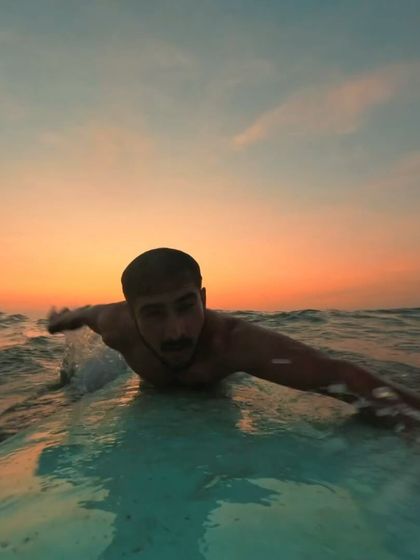 A personal photo of me on a surfboard at sunset. This image captures the feeling of being one with the water and the simple joy of learning a new skill.