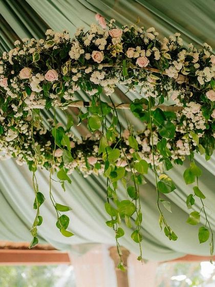 A beautiful floral chandelier made of white and pink roses, hanging from the ceiling of our open-air pavilion.