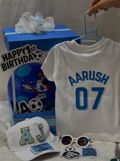Here are some of the personalized items from the football birthday hamper, including a custom jersey-style t-shirt and an initialed cap.